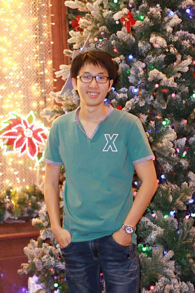 Tony Nguyen smiling in a green plaid shirt and tortoise shell glasses